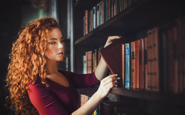 Library woman reading book blurry free wallpaper for desktop - medium preview image