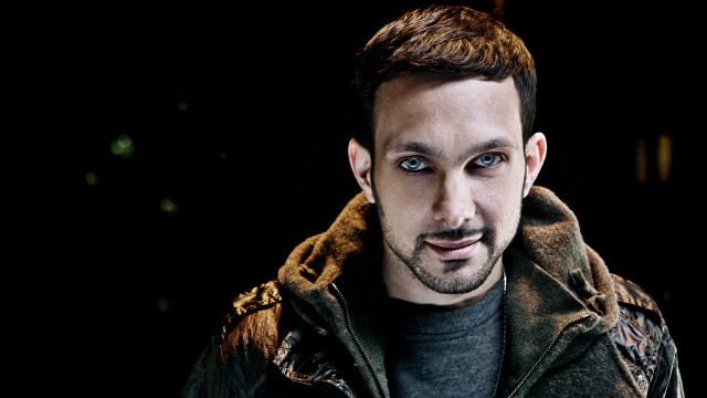 Man goatee jacket smirk camera free wallpaper for desktop - medium preview image