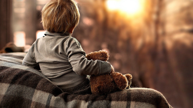 Boy sitting on couch with free wallpaper for desktop - medium preview image