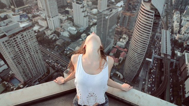 Woman cityscape ledge outstretched arms free wallpaper for desktop - medium preview image