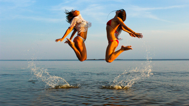 Two women jumping into water free wallpaper for desktop - medium preview image