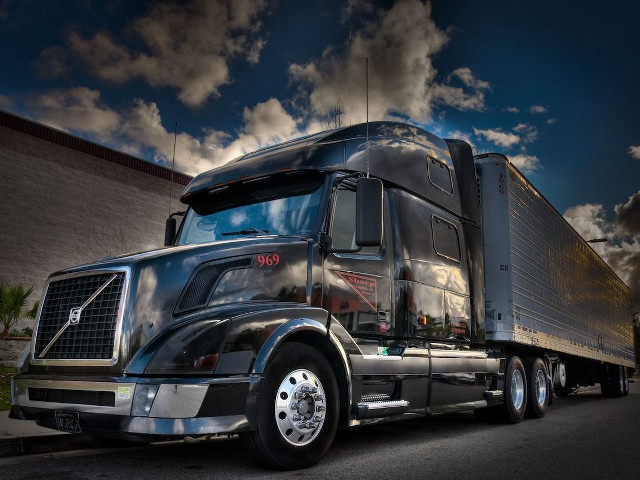 Semi truck parked building cloudy free wallpaper for desktop - medium preview image