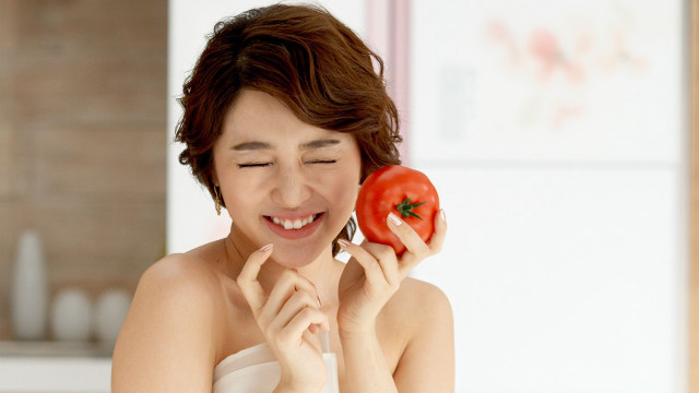 Woman holding tomato smiling camera free wallpaper for desktop - medium preview image