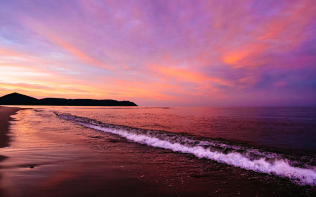 Beach wave sunset mountain distance free wallpaper for desktop - medium preview image