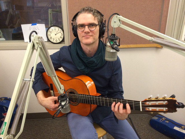 Man sitting chair guitar headphones free wallpaper for desktop - medium preview image