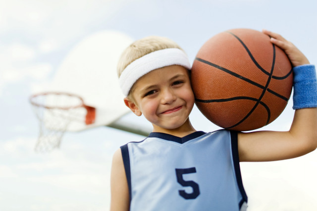Young boy holding basketball smiling free wallpaper for desktop - medium preview image