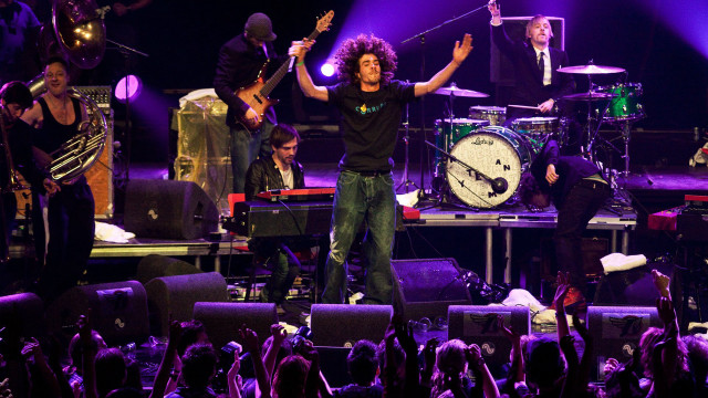 Man standing stage arms raised free wallpaper for desktop - medium preview image