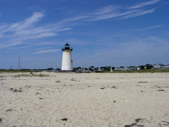 Lighthouse sandy beach blue sky free wallpaper for desktop - medium preview image