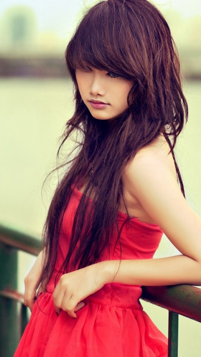 Woman red dress leaning rail free wallpaper for mobile - medium preview image