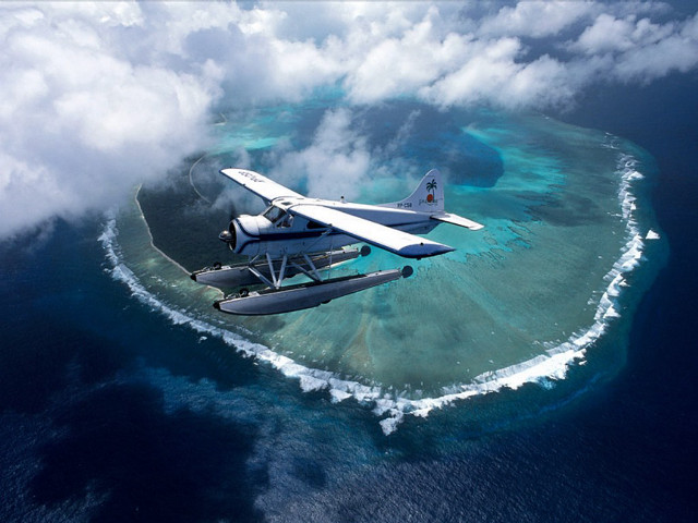 Plane flying small island ocean free wallpaper for desktop - medium preview image