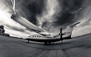 Small plane tarmac cloudy sky - wide angle len free wallpaper