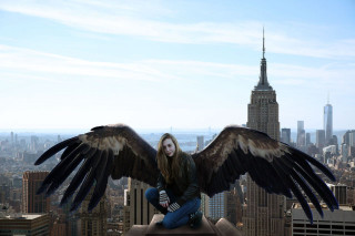 Woman wings sitting ledge city - a ledge in a city free wallpaper