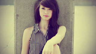 Woman leaning wall hand hip 5 - pale free wallpaper