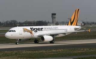 Tiger airlines plane runway airport - a tower in the background free wallpaper