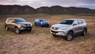 Suvs parked field mountains cloudy - a cloudy sky above them free wallpaper