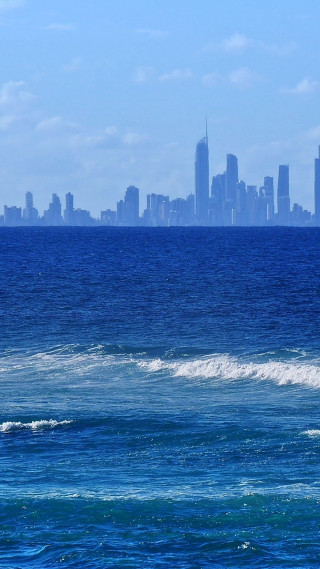 Man surfboard wave ocean city - a man riding free wallpaper for mobile