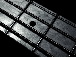 Guitar neck closeup black background 3 - a close up of a guitar neck free wallpaper