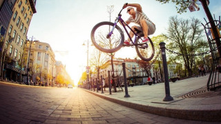 Man bike jumping street corner - a city street in the background free wallpaper