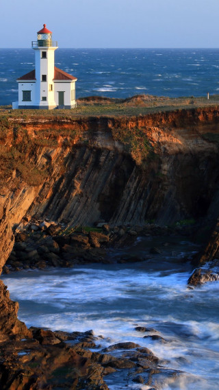 Lighthouse cliff ocean waves crashing 2 - free landscape wallpaper for mobile