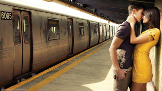 Man woman kissing train station - a train in the background free wallpaper