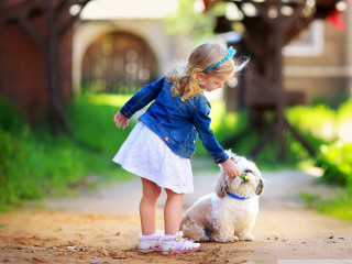Little girl petting small dog - a house in the background free wallpaper