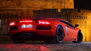 Red sports car night building 5 - a clock tower in the background free wallpaper