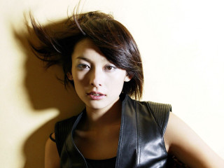 Woman black leather vest hair - a white wall behind her free wallpaper