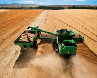 Green tractor driving field grain - a machine free wallpaper for desktop