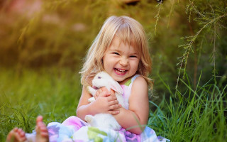 Little girl holding bunny smiling - a little girl holding free wallpaper