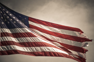 American flag flying cloudy sky - a sunbeam in the background free wallpaper