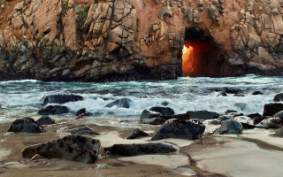 Cave entrance red light ocean - a rocky beach free wallpaper