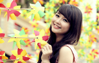 Woman holding pinwheels smiling colorful - a background free wallpaper