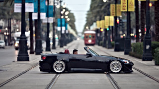 Black convertible car driving street - clean line free wallpaper