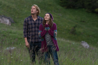 Man woman field grass sky - a hill in the background free wallpaper