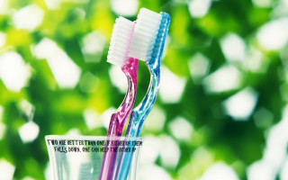 Two toothbrushes in glass with - alive free wallpaper