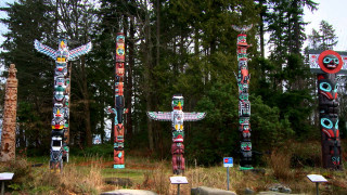 Totem poles forest trees background - sculpture free wallpaper