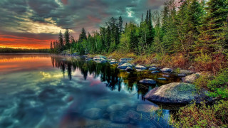 Sunset lake rocks trees cloudy - a beautiful sunset over a lake free wallpaper