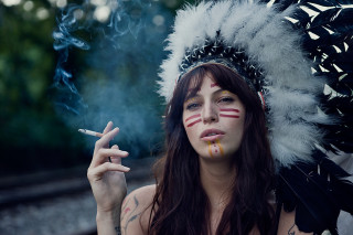 Woman feather headdress smoking cigarette - her hand and a cigarette free wallpaper