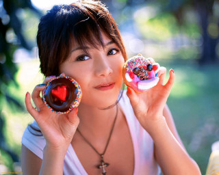 Woman holding two donuts with - sprinkle free wallpaper