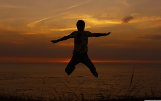 Man jumping sunset ocean arms - his hands out free wallpaper for desktop