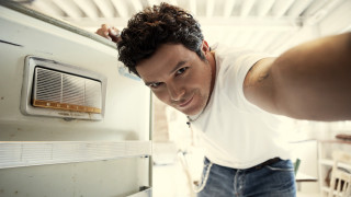 Man leaning refrigerator smiling looking - the camera man free wallpaper for desktop