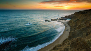 Sunset beach waves cliff water - a sunset over a beach free wallpaper