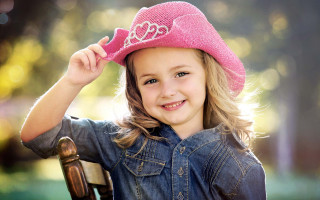 Little girl pink hat smiling 4 - a wooden chair free wallpaper