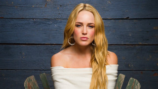 Woman blonde hair chair blue - a wooden wall behind her free wallpaper