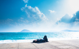 Person laying ground ocean sky - the sky above them free wallpaper