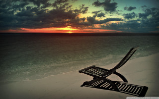 Chair beach sunset cloudy sky - a sandy beach under a cloudy sky free wallpaper