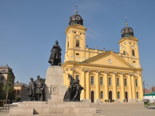 Large yellow building statues clock - a clock tower in the background free wallpaper