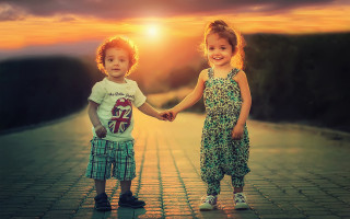 Two little girls holding hands - a brick road free wallpaper