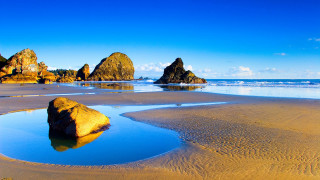 Beach rock formation water sky - a rock formation in the middle of it free wallpaper