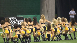 Cheerleaders performing field game man - a man in the background free wallpaper